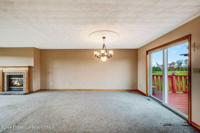 unfurnished living room featuring a fireplace, carpet floors, and a chandelier