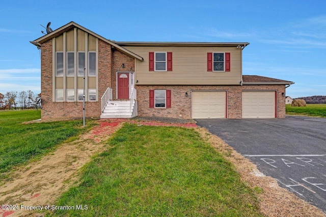 raised ranch featuring a garage and a front yard