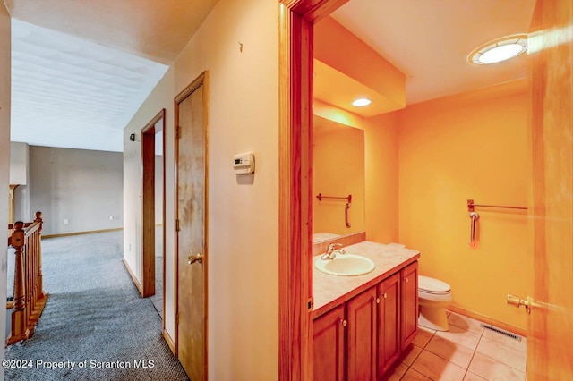 bathroom featuring tile patterned flooring, vanity, and toilet