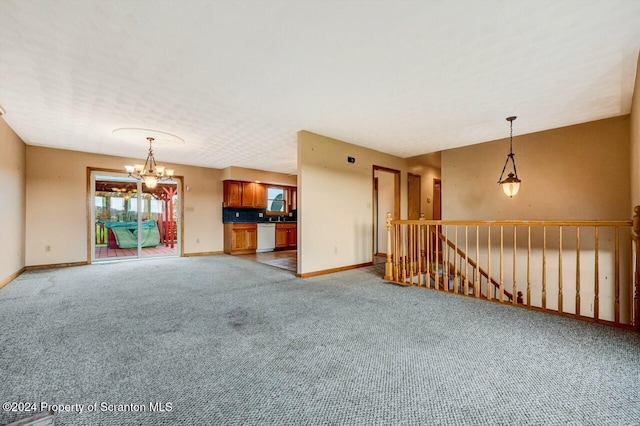 empty room with carpet floors and an inviting chandelier