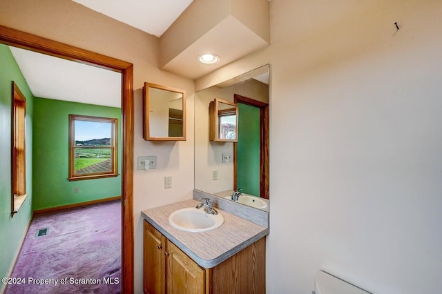 bathroom featuring baseboard heating, vanity, and toilet