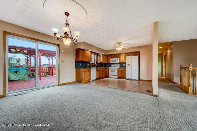 kitchen with light carpet, white appliances, ceiling fan with notable chandelier, and hanging light fixtures