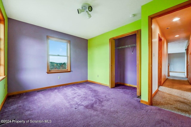 unfurnished bedroom featuring light colored carpet and a closet