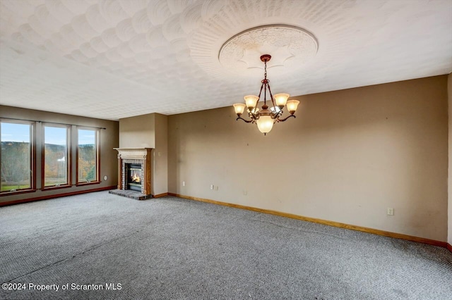 unfurnished living room featuring a chandelier, a textured ceiling, and carpet flooring