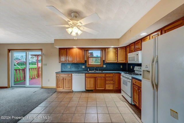 kitchen featuring white appliances, backsplash, sink, ceiling fan, and light tile patterned floors