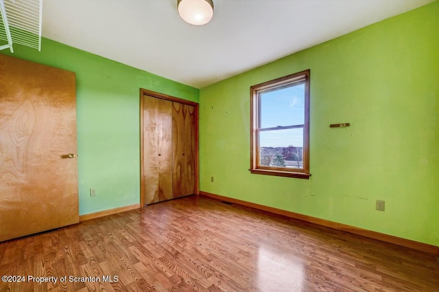 unfurnished bedroom featuring a closet and light wood-type flooring