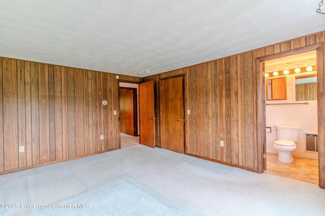 474 Tingley Lake Rd, New Milford, PA 18834 - unfurnished bedroom with carpet, wood walls, ensuite bath, and baseboards