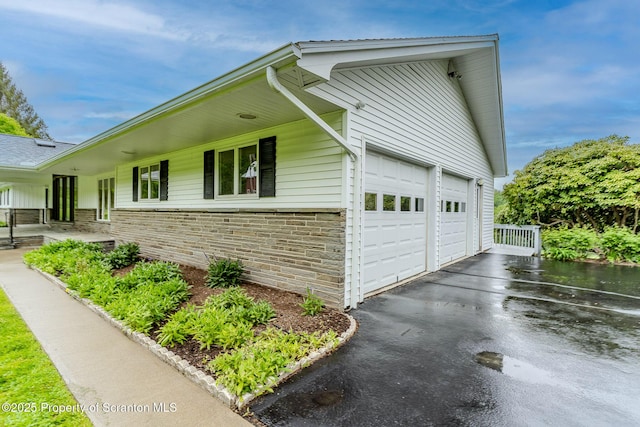 474 Tingley Lake Rd, New Milford, PA 18834 - view of property exterior featuring a garage, stone siding, and asphalt driveway