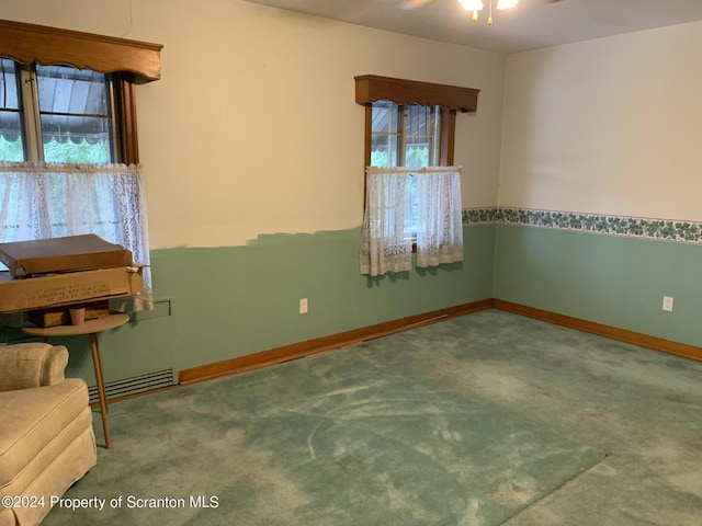 carpeted empty room with ceiling fan and plenty of natural light