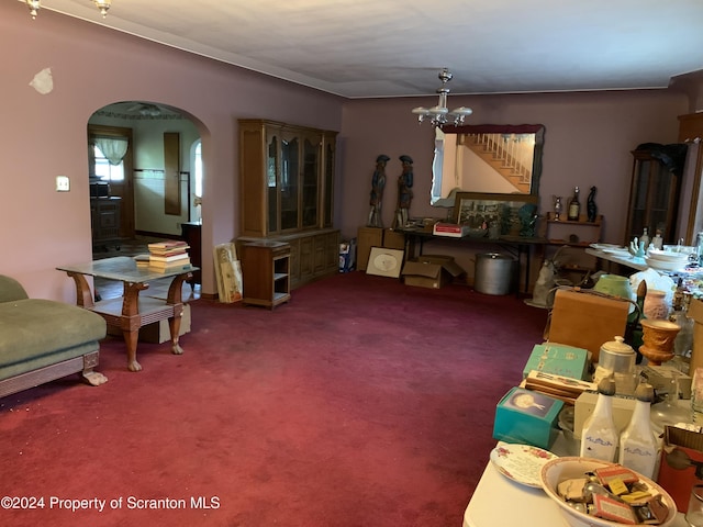 carpeted living room with a notable chandelier