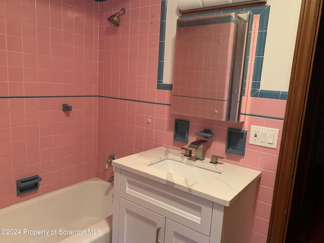 bathroom with vanity, tile walls, tiled shower / bath combo, and tasteful backsplash