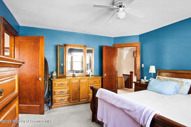 bedroom with a ceiling fan and light colored carpet
