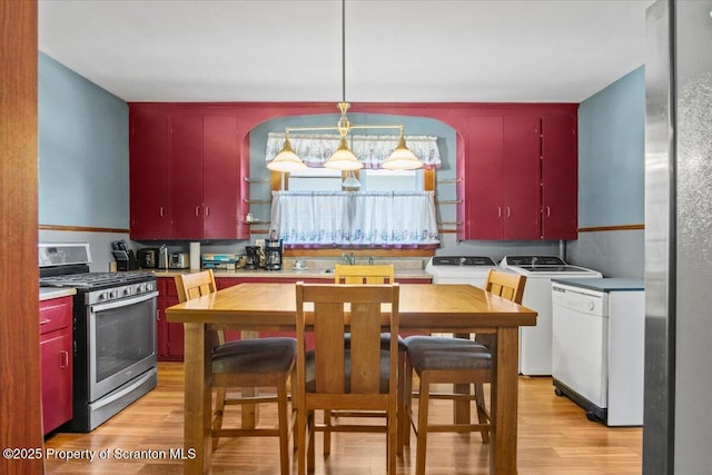 kitchen featuring red cabinetry, washing machine and dryer, light wood-style floors, dishwasher, and gas stove