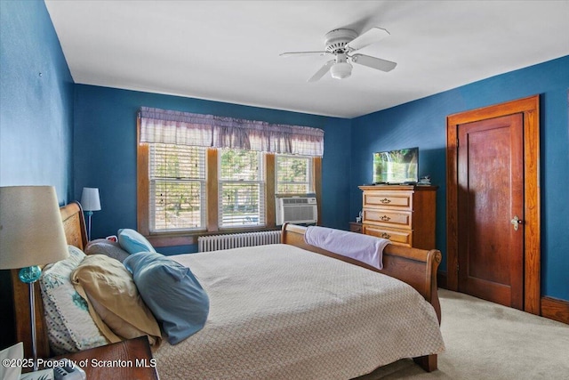carpeted bedroom with ceiling fan, radiator, and cooling unit