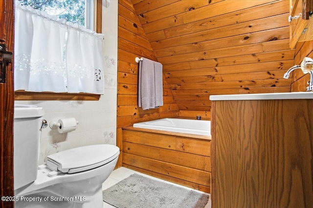 bathroom featuring wooden walls, toilet, and a tub to relax in