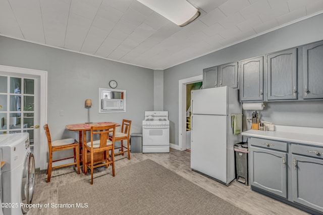 kitchen with white appliances, light wood-style flooring, washer / clothes dryer, and gray cabinetry