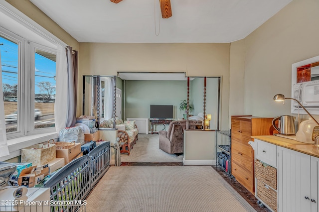 sitting room with ceiling fan and carpet flooring