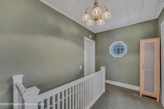 hall featuring an upstairs landing, carpet flooring, baseboards, and ornamental molding