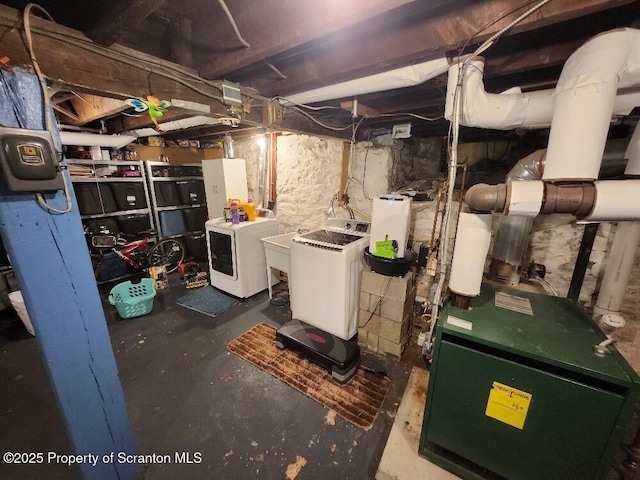 unfinished basement with a heating unit and independent washer and dryer