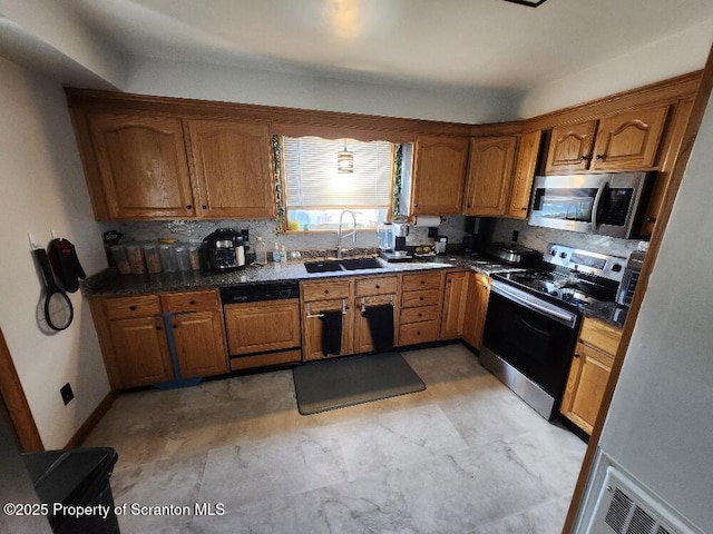 kitchen with stainless steel appliances, brown cabinetry, a sink, and decorative backsplash