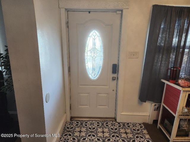 foyer entrance with radiator, baseboards, and tile patterned floors