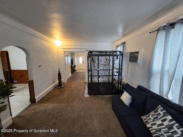 carpeted living room featuring arched walkways