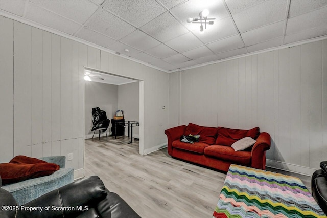 living area featuring a paneled ceiling and wood finished floors