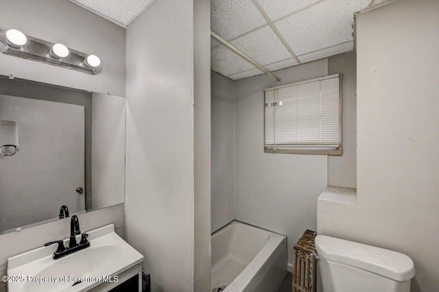 bathroom featuring a paneled ceiling, vanity, toilet, and bathing tub / shower combination