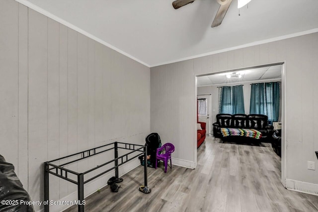 interior space featuring baseboards, crown molding, and wood finished floors