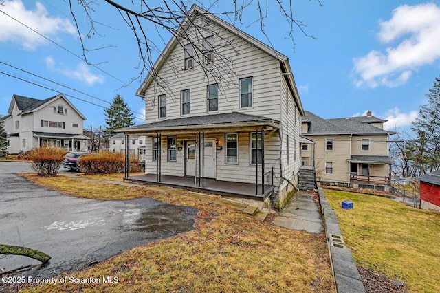 view of front of property featuring covered porch and a front lawn