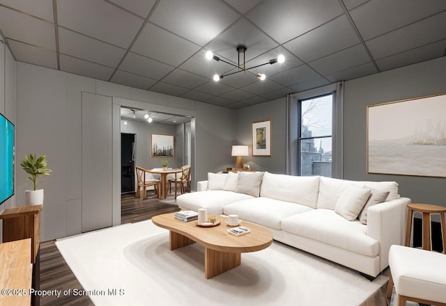 living area featuring wood finished floors and a paneled ceiling