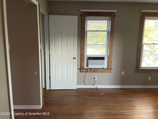 unfurnished bedroom with dark hardwood / wood-style flooring and cooling unit