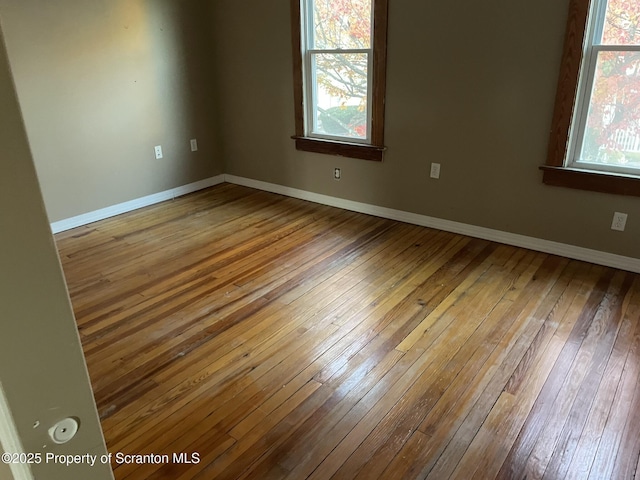 unfurnished room featuring a healthy amount of sunlight and hardwood / wood-style flooring