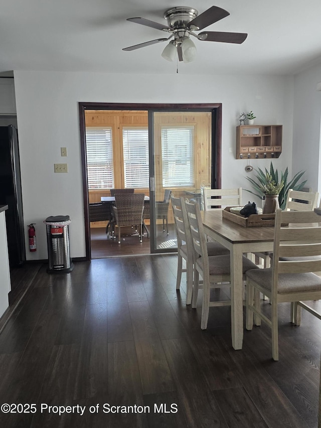 dining area with a wealth of natural light, ceiling fan, and dark wood-type flooring