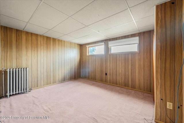 205 Lackawanna Ave, Duryea, PA 18642 - empty room featuring radiator heating unit, a drop ceiling, wooden walls, and carpet floors