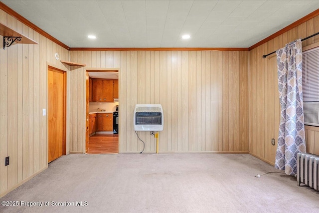 205 Lackawanna Ave, Duryea, PA 18642 - unfurnished living room featuring heating unit, ornamental molding, carpet floors, radiator, and wood walls