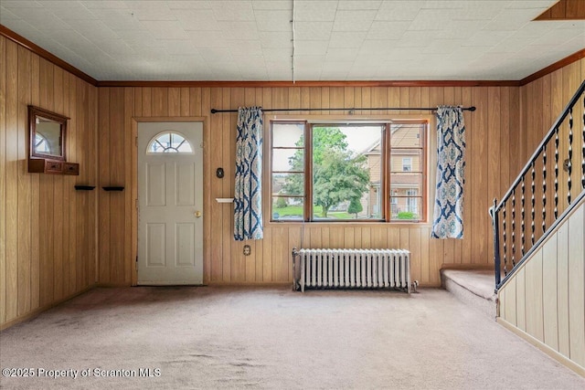 205 Lackawanna Ave, Duryea, PA 18642 - carpeted entryway with radiator heating unit, stairway, wood walls, and ornamental molding