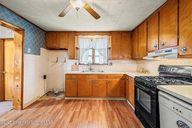 205 Lackawanna Ave, Duryea, PA 18642 - kitchen with white dishwasher, gas stove, brown cabinetry, wallpapered walls, and wainscoting
