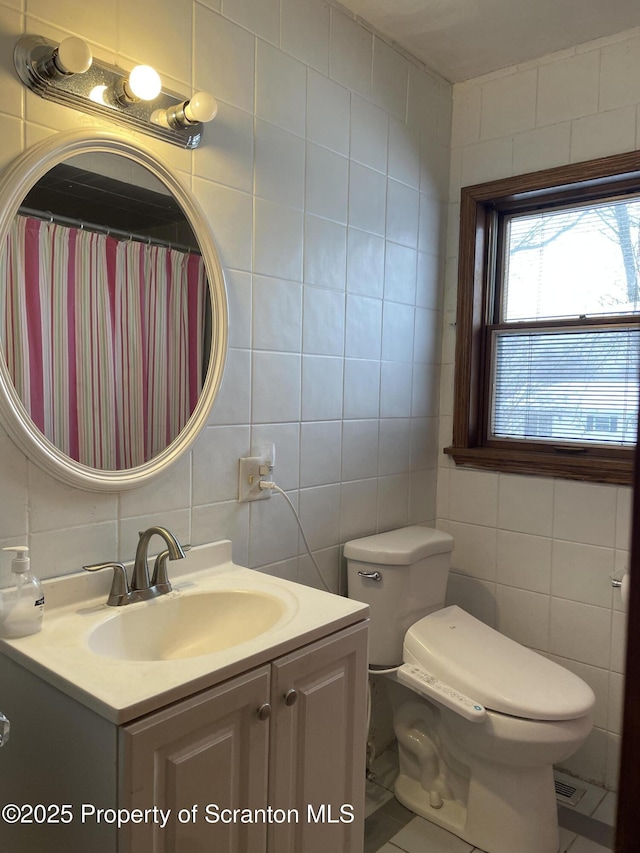 bathroom with toilet, vanity, tile walls, and decorative backsplash