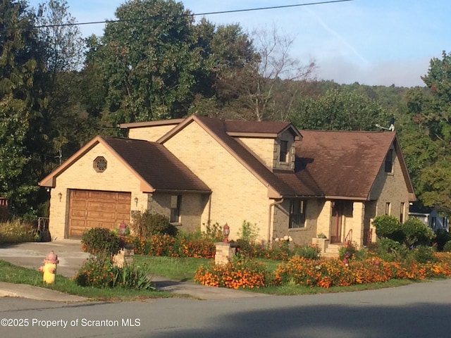 view of front of home with an attached garage, driveway, and brick siding