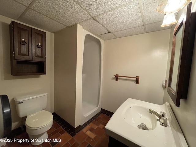 bathroom featuring a stall shower, baseboards, toilet, vanity, and a paneled ceiling