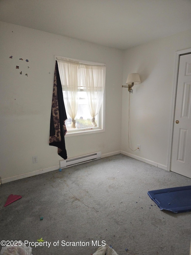 spare room featuring baseboards, baseboard heating, and carpet floors