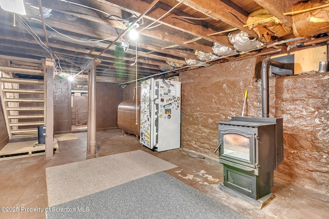 50 Humphrey St Unit 50-51, Old Forge, PA 18518 - unfinished basement featuring freestanding refrigerator, oil tank, and a wood stove