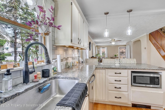 50 Humphrey St Unit 50-51, Old Forge, PA 18518 - kitchen with appliances with stainless steel finishes, a peninsula, a ceiling fan, light wood finished floors, and decorative light fixtures