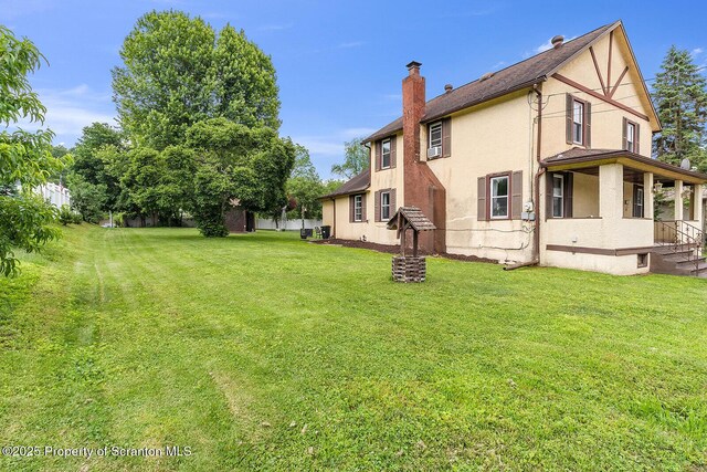 50 Humphrey St Unit 50-51, Old Forge, PA 18518 - back of house with stucco siding, a chimney, and a lawn