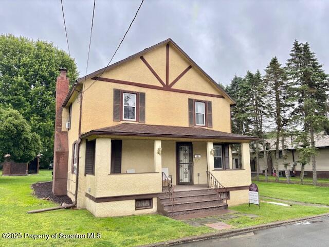 50 Humphrey St Unit 50-51, Old Forge, PA 18518 - tudor home featuring stucco siding, covered porch, a chimney, and a front yard