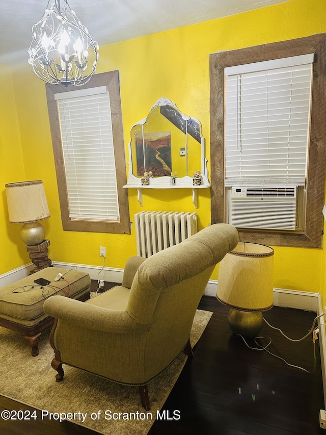 living area with radiator heating unit, an inviting chandelier, and cooling unit