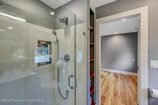 bathroom featuring hardwood / wood-style flooring and walk in shower