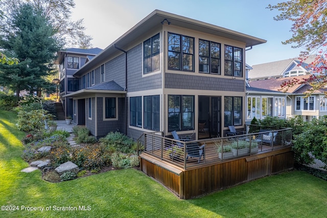 back of property featuring a sunroom and a yard