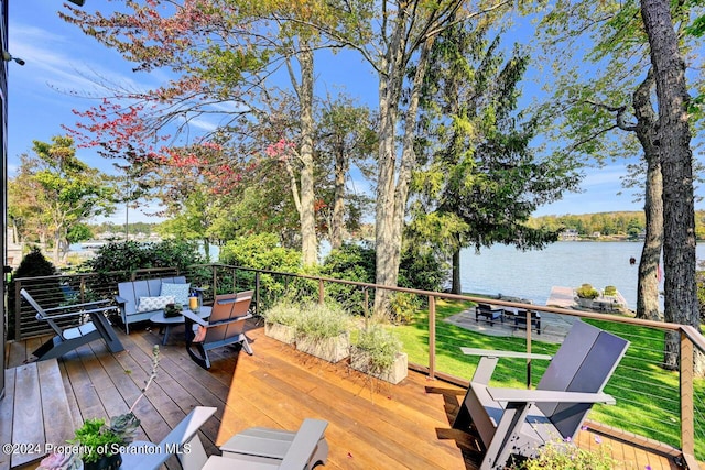 deck with an outdoor living space, a yard, and a water view